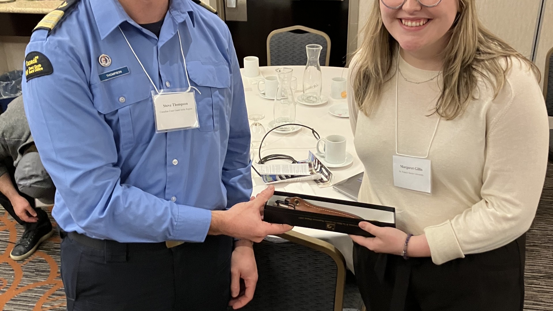 A police officer and a young woman holding an award