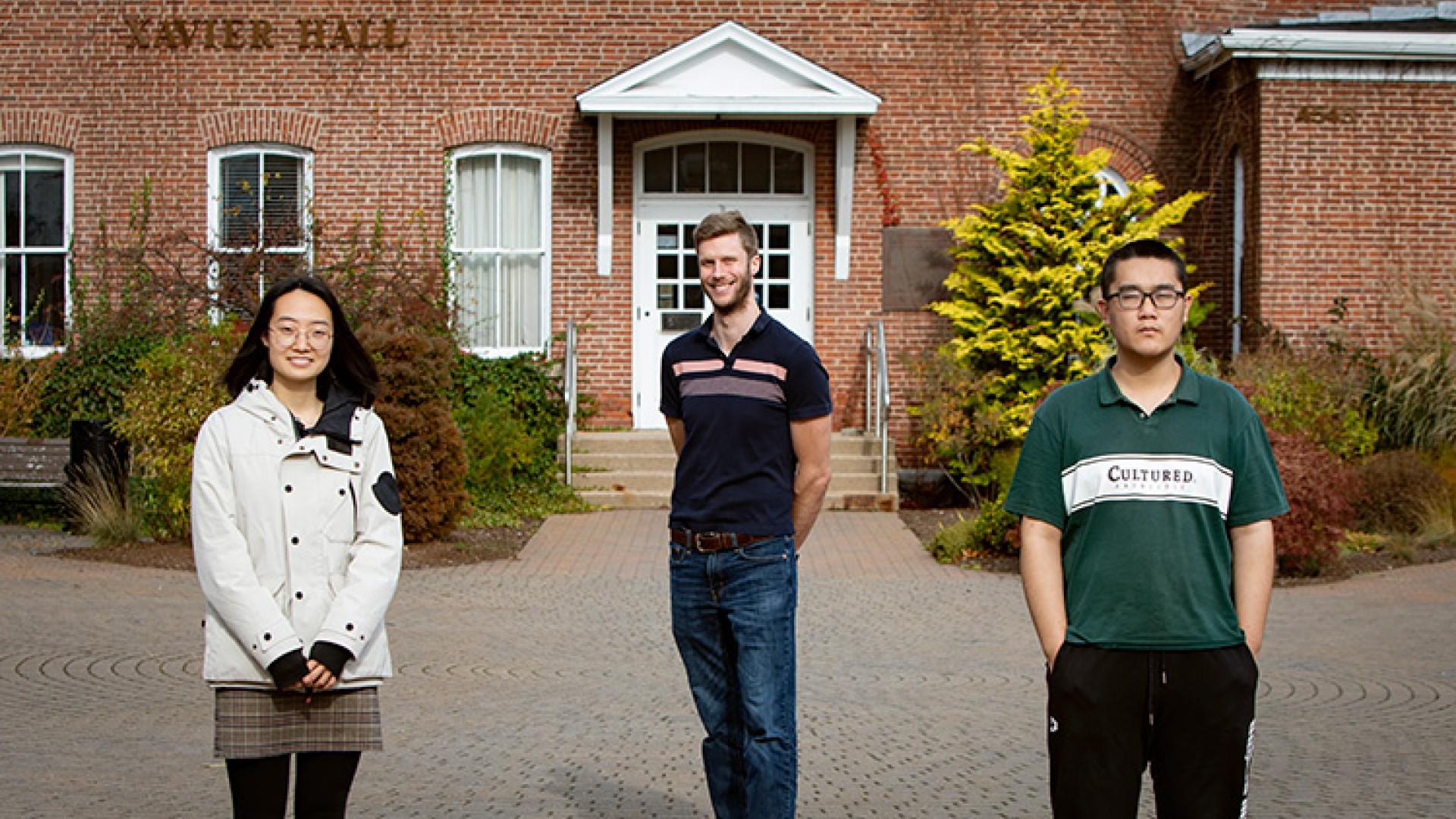 Three people standing in front of a building