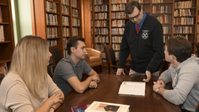 Students and their professor at a table