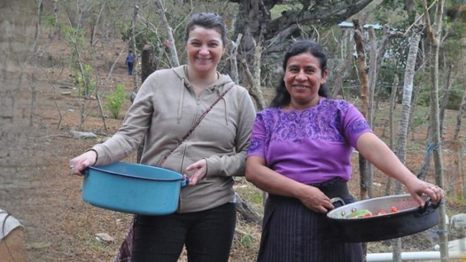 Student participating in a Service Learning project through the StFX Bachelor of Arts program, collecting produce in a rural community setting.