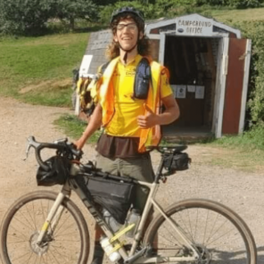 Student standing outside with his bike 