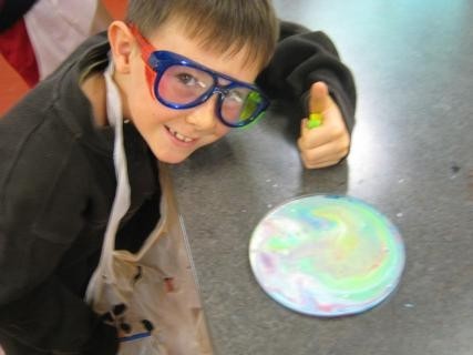 A young boy wearing goggles and a black jacket