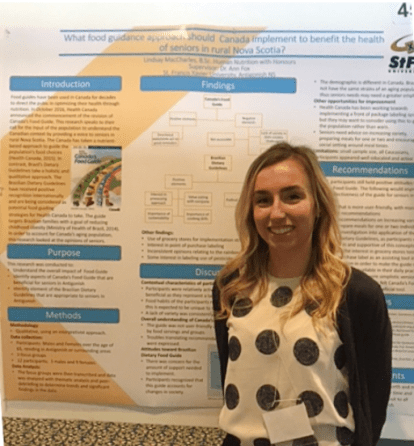 Student standing with their project