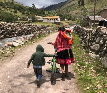 Mother and child walking next to a bike